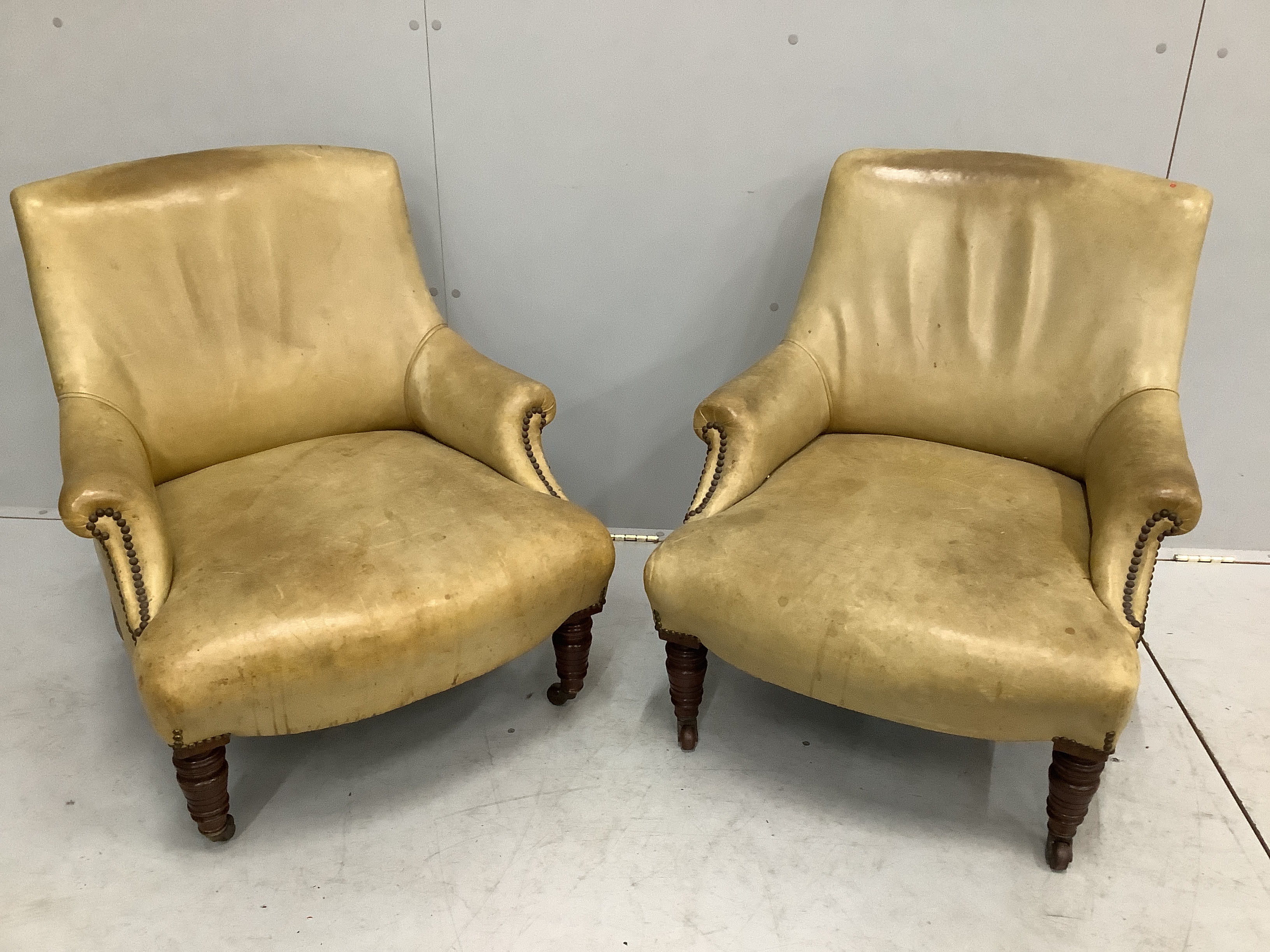 A pair of late Victorian studded leather upholstered armchairs, width 67cm, depth 70cm, height 75cm